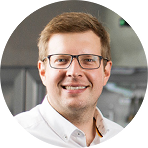 Mann mit Brille und weißem Hemd lächelt