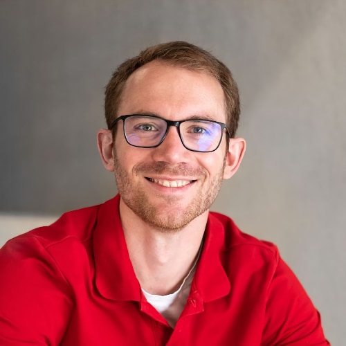 Mann mit Brille und rotem Hemd lächelt